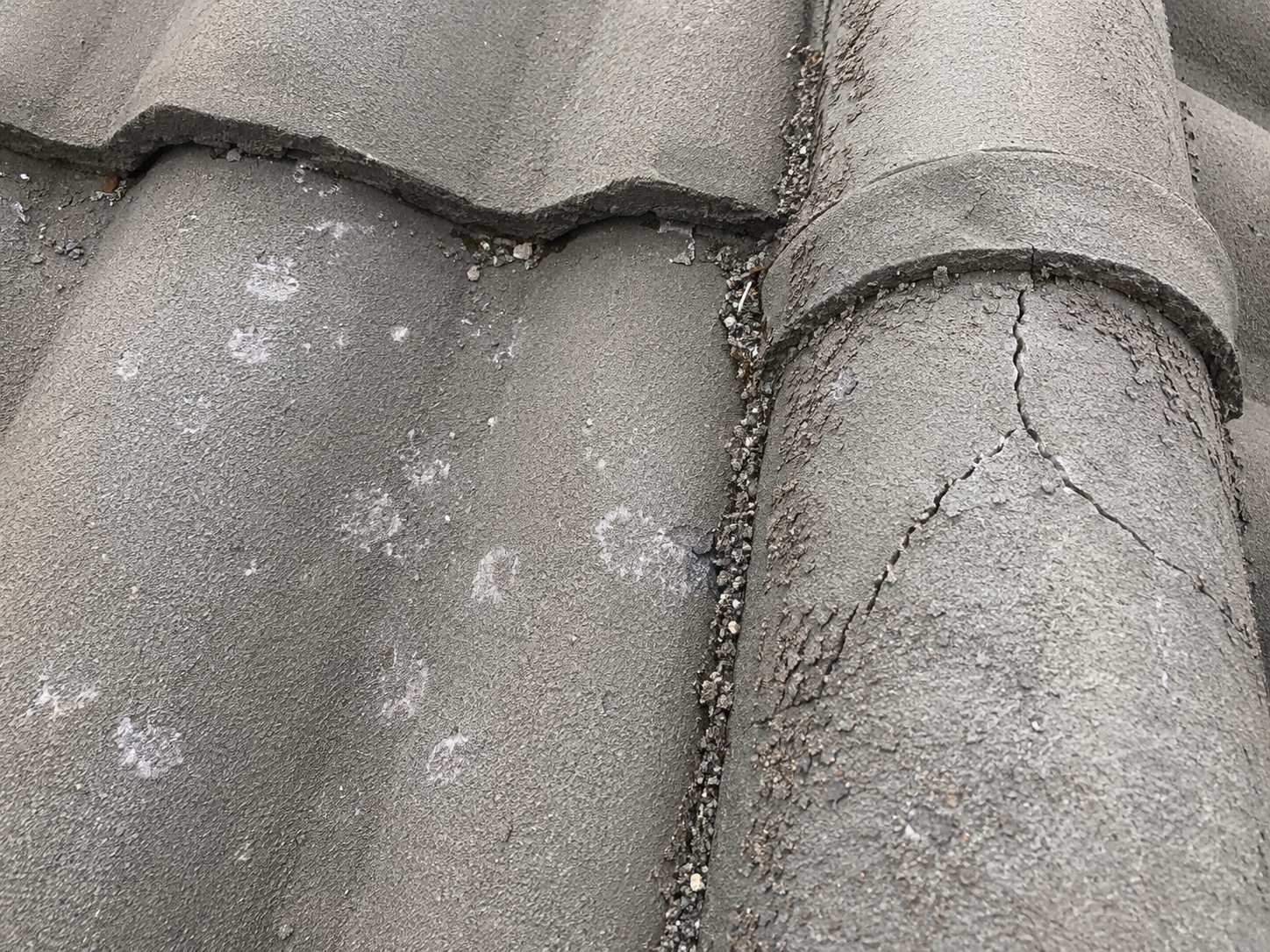 Hail-bruised tile and cracked ridge